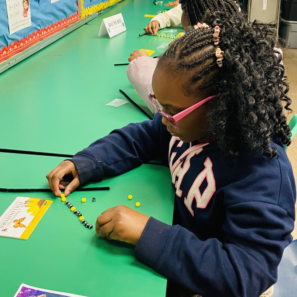 A girl making a bead bracelet.